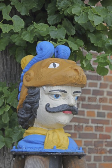 Colourful Swedish head as a landmark, historic wooden head with face and four eyes, tree house, Old