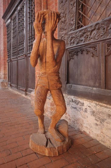 Wooden figure with hands in front of the face, interior view, wooden sculpture, modern art, wood
