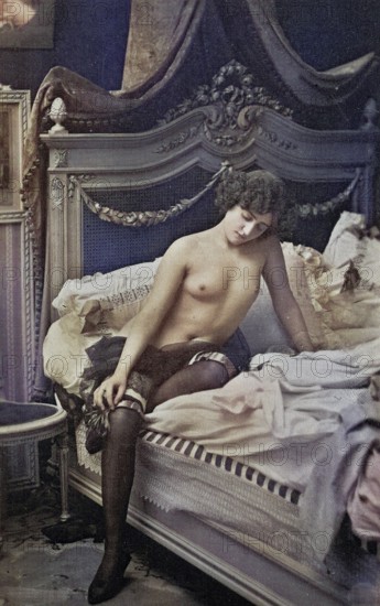 Female nude from around 1899, erotic postcard, Playgirl, A woman sits thoughtfully on a bed in a
