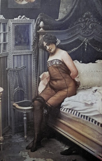 Female nude from around 1899, erotic postcard, Playgirl, A woman in a nude corset sits on a bed in