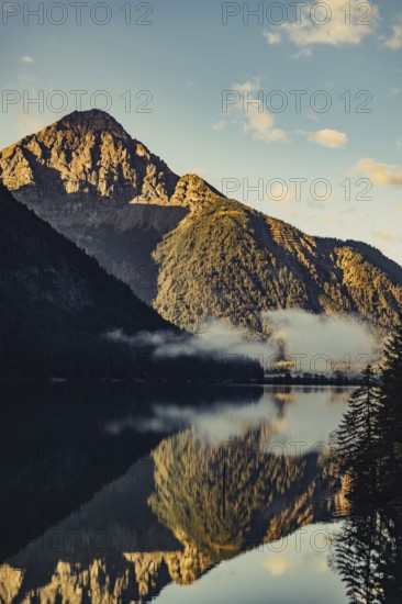 Sunrise with reflections and alpenglow in Lake Heiterwanger See in Tyrol in the Alps in Austria