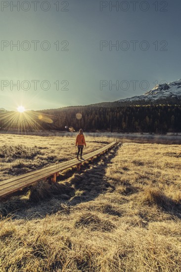 Young woman at Lake Staz near Sankt Moritz in the Engadine in Switzerland. Morning atmosphere with
