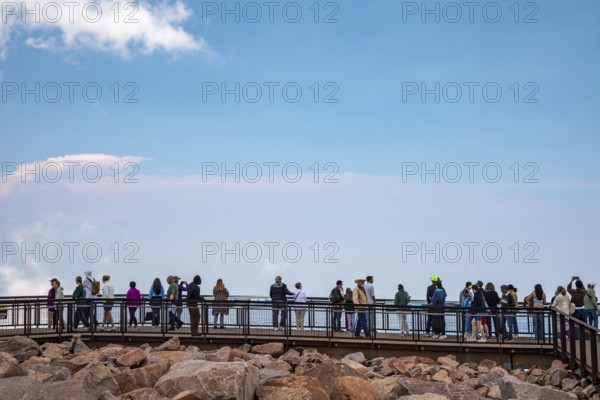 Colorado Springs, Colorado - Tourists line a viewing plantform at the summit of Pikes Peak, a 14,