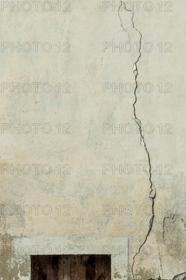 A cracked wall surface shows the passage of time with visible wear. The texture highlights light