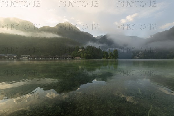 Mystical morning at Königssee in Schönau with boathouses and Christlieger. Sunrise and beautiful