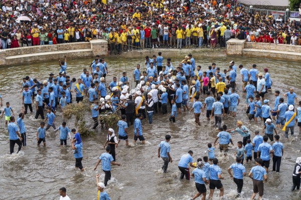 People from the Pnar community perform rituals as they using a tree to celebrate an event organised