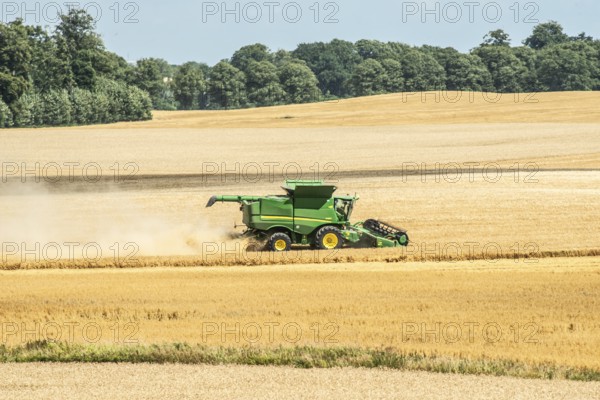 Landscape with threshing of grain with combine harvester at Ystad, Skåne county, Sweden,