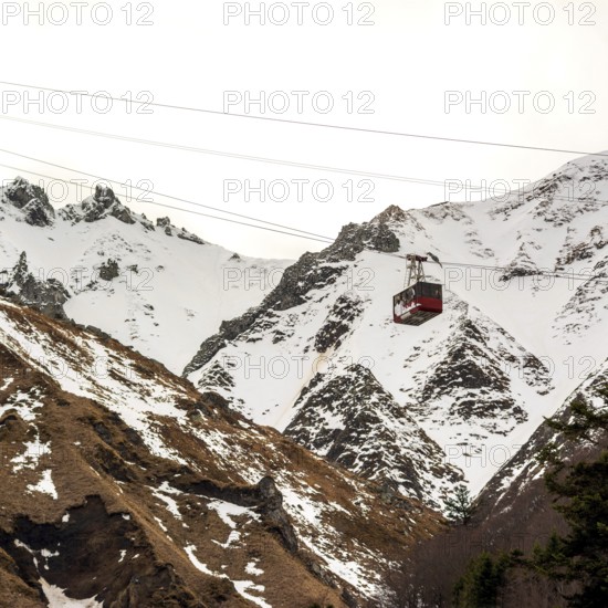 A gondola ascends the stunning Massif of Sancy, surrounded by a winter wonderland of snow-covered