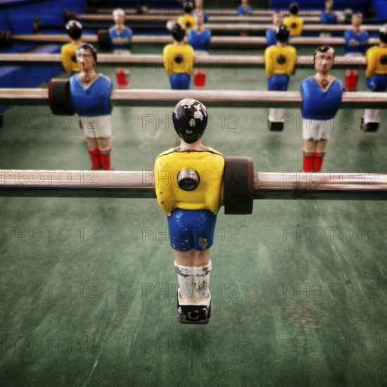 In a vibrant recreation space, a vintage table football game features colorful player figurines