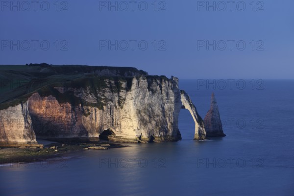 Cliffs with the Falaise d'Aval rock gate and the Aiguille d'Etretat rock needle at night, Etretat,