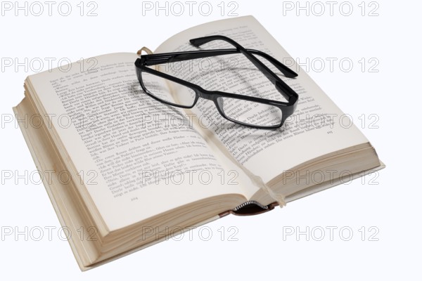 Reading glasses and book on a white background