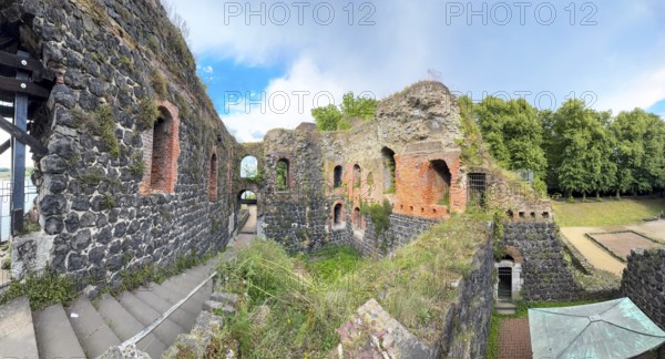 Panoramic photo of interior of northern inner part with partially restored secured masonry of ruins