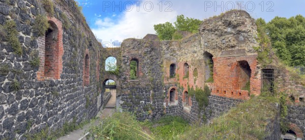 Panoramic photo of interior of northern inner part with partially restored secured masonry of ruins