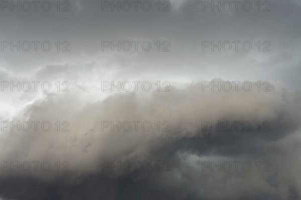 Below dark discoloured storm clouds Cloud roll above grey clouds Rain clouds heralding