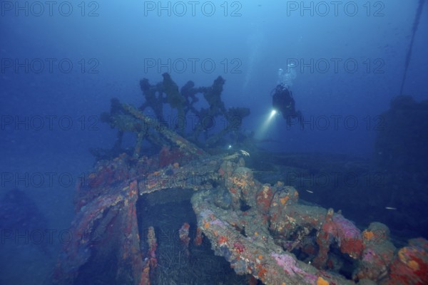 A diver explores a rusty shipwreck on the seabed. Dive site wreck Ville de Grasse, Giens peninsula,