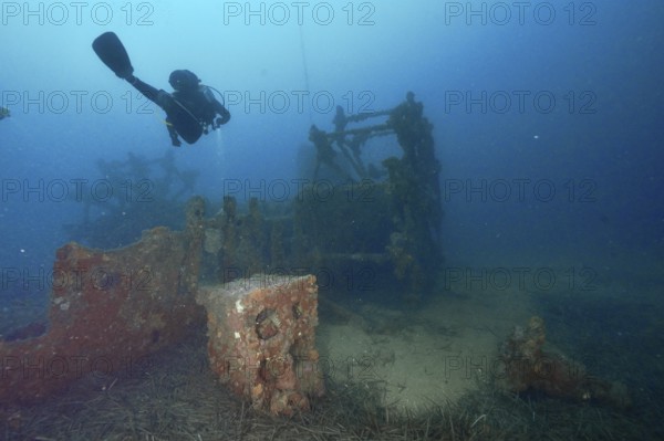 A diver examines an old shipwreck on the seabed. Dive site wreck Ville de Grasse, Giens peninsula,