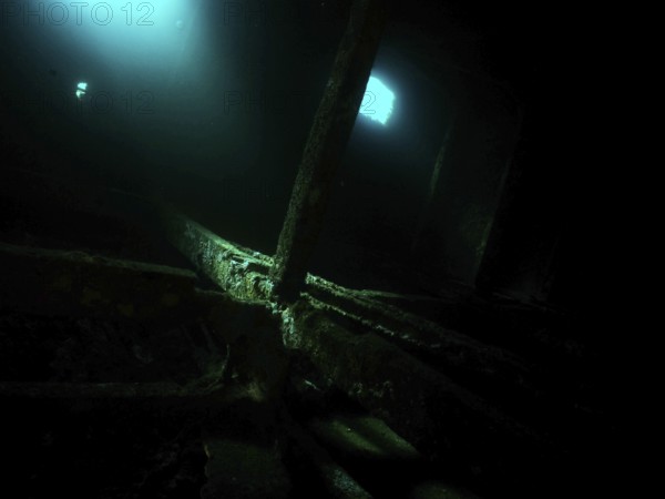 A mysterious, dark room in the shipwreck with blue light and shadows. Dive site wreck of the