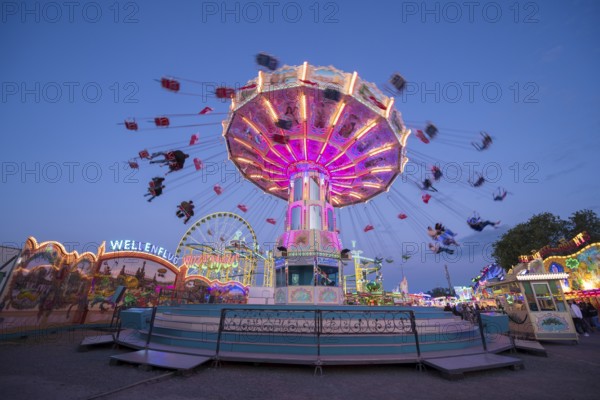 Colourful carousel in motion at a night fair, chain carousel, spring festival, Cannstatter