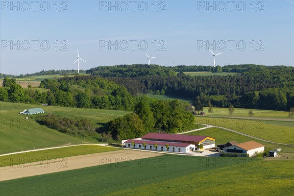 Idyllic rural scene with windmills, green fields and a farm under a blue sky, near Westerheim,