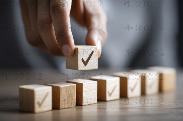 Checklist and task progress tracking concept. A hand placing the final checkmark on wooden blocks