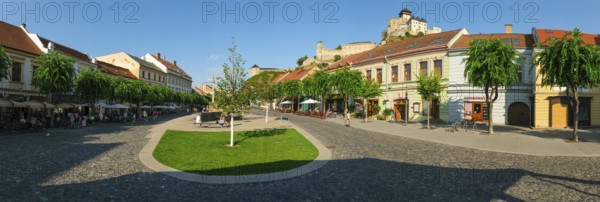 Peace Square with cafés in the old town centre of Trencin, Trencin Castle in the background,