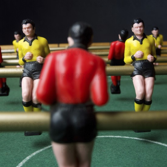 Engaged players immerse themselves in a lively tabletop football game, surrounded by vibrant player