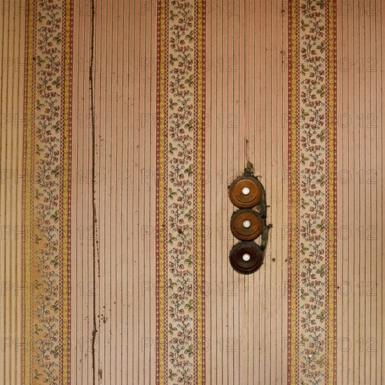 Intricate floral designs and charming stripes decorate the walls of an old building, while three