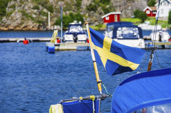 The Swedish flag flies at the stern of a boat in the marina of Henan on Orust, Bohuslän, Västra