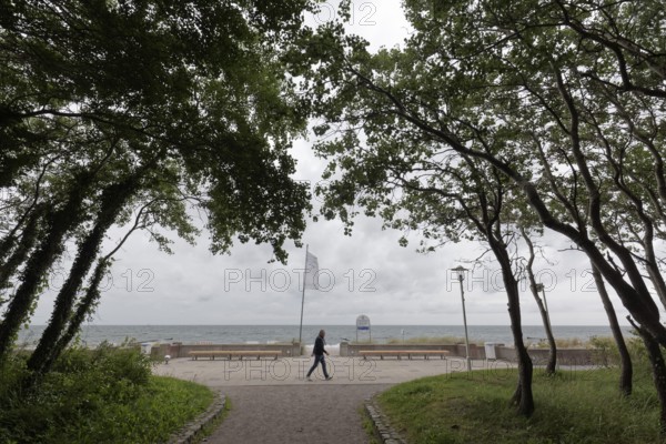 Single person walking along the beach promenade, cloudy sky, Baltic resort Kühlungsborn, Baltic