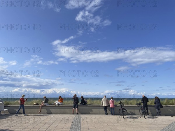People on the beach promenade looking out to sea, blue sky, Baltic resort Kühlungsborn, Baltic Sea,