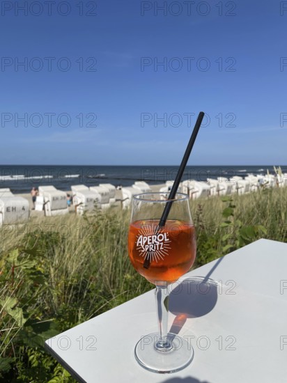 Glass of Aperol Spritz on a table overlooking the beach, Baltic resort Kühlungsborn,