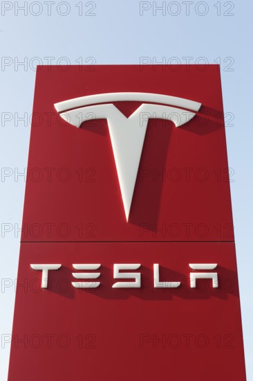 Tesla, pillar with logo in front of Tesla repair shop, US car manufacturer for electric cars,