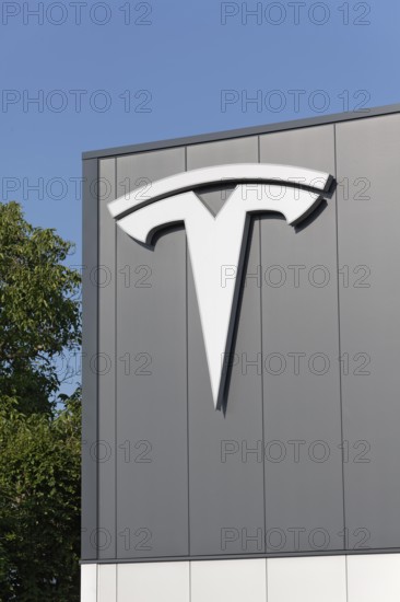 Tesla, logo on modern workshop building, figurative mark without lettering, US car manufacturer for