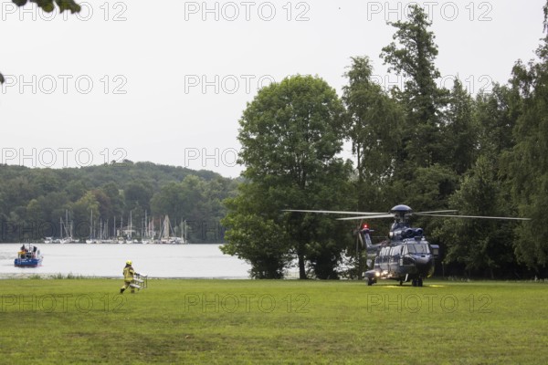 A firefighter transports a ladder to a helicopter in front of a joint meeting between Friedrich