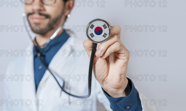 Doctor holding stethoscope with South Korea flag. South Korea health and care concept, South Korea