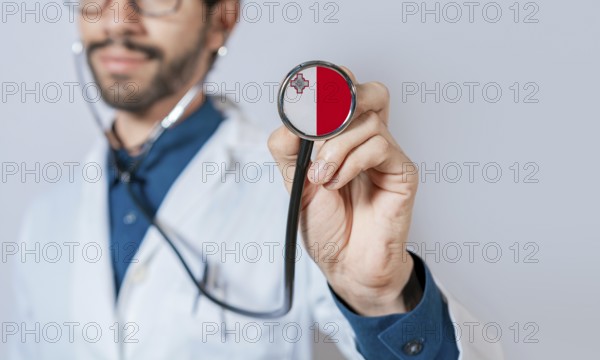 Doctor holding stethoscope with Malta flag. Malta health and care concept, Malta flag on