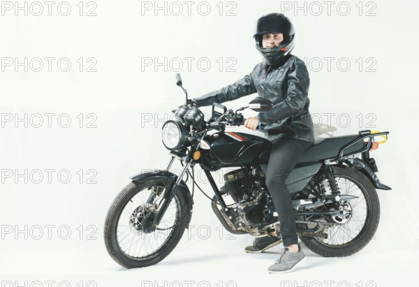 Male motorcyclist riding his motorcycle on isolated background. Smiling young man riding a