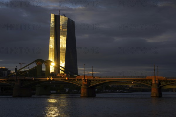 The light of the setting sun is reflected on the glass façade of the European Central Bank (ECB) in