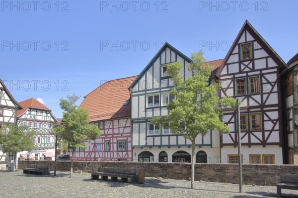 Colourful half-timbered houses, red, green, brown, empty benches, churchyard, Schmalkalden,