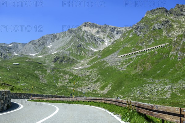 View of front curves of pass road mountain road alpine road above tree line, in the centre right in