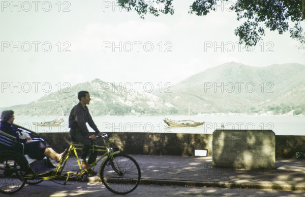 Tricycle rickshaw rider by coastline, Avenida da Republica, Macau, Asia 1964 now Sai Van Lake, Lago