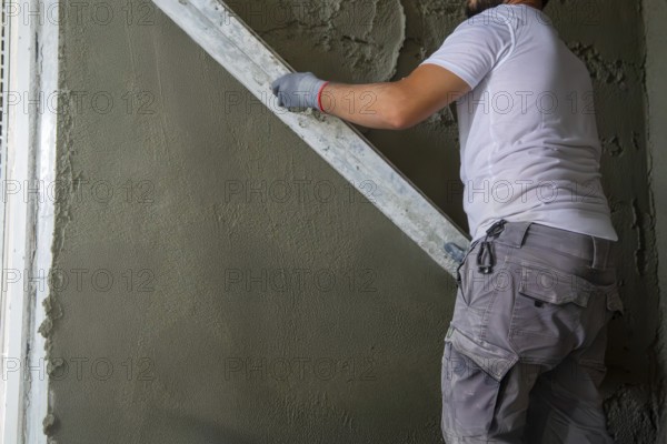 Plasterer smoothing interior walls