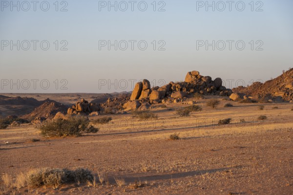 Barren landscape with hills of stacked rocks, desert landscape in the evening light at sunset,