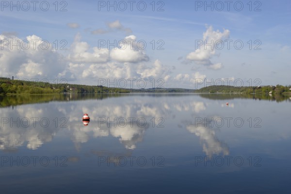 View over the Möhnesee, Möhnesee tower, red and white buoy, blue cloudy sky, reflection on the