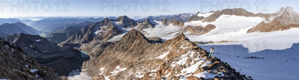Mountaineer on a rocky ridge on the Wilder Freiger mountain peak, behind signal peak and Becher