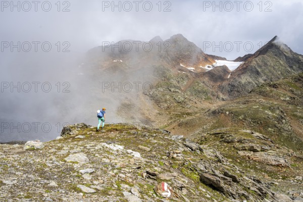 Mountaineer on a hiking trail, cloudy mountain landscape, Egetenjoch, Seven Lakes Hike, Stubai