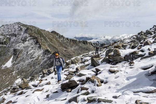 Two female mountaineers in boulder terrain with fresh snow in summer, ascent to the summit Böses