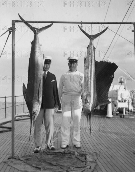 Swordfish (Xiphias gladius) and fanfish (Istiophorus platypterus), two sailors on a ship, ca. 1930s