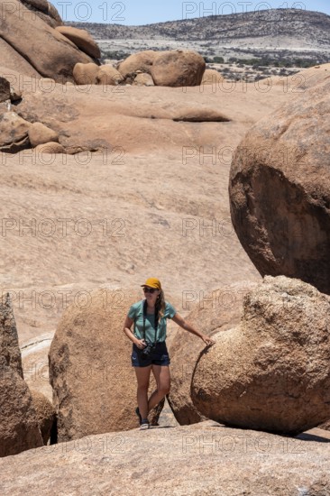 Tourist with camera, rock formation, Pontok Mountains, Spitzkoppe, Große Spitzkuppe Nature Reserve,