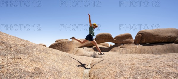 Tourist jumping over rocks, rock formation, Pontok Mountains, Spitzkoppe, Great Spitzkuppe Nature